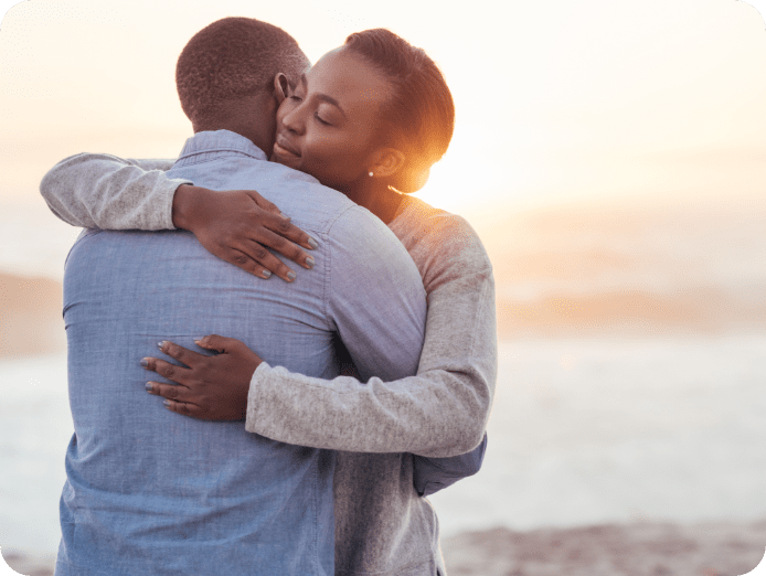 Lady and gent hugging outdoors during sunset